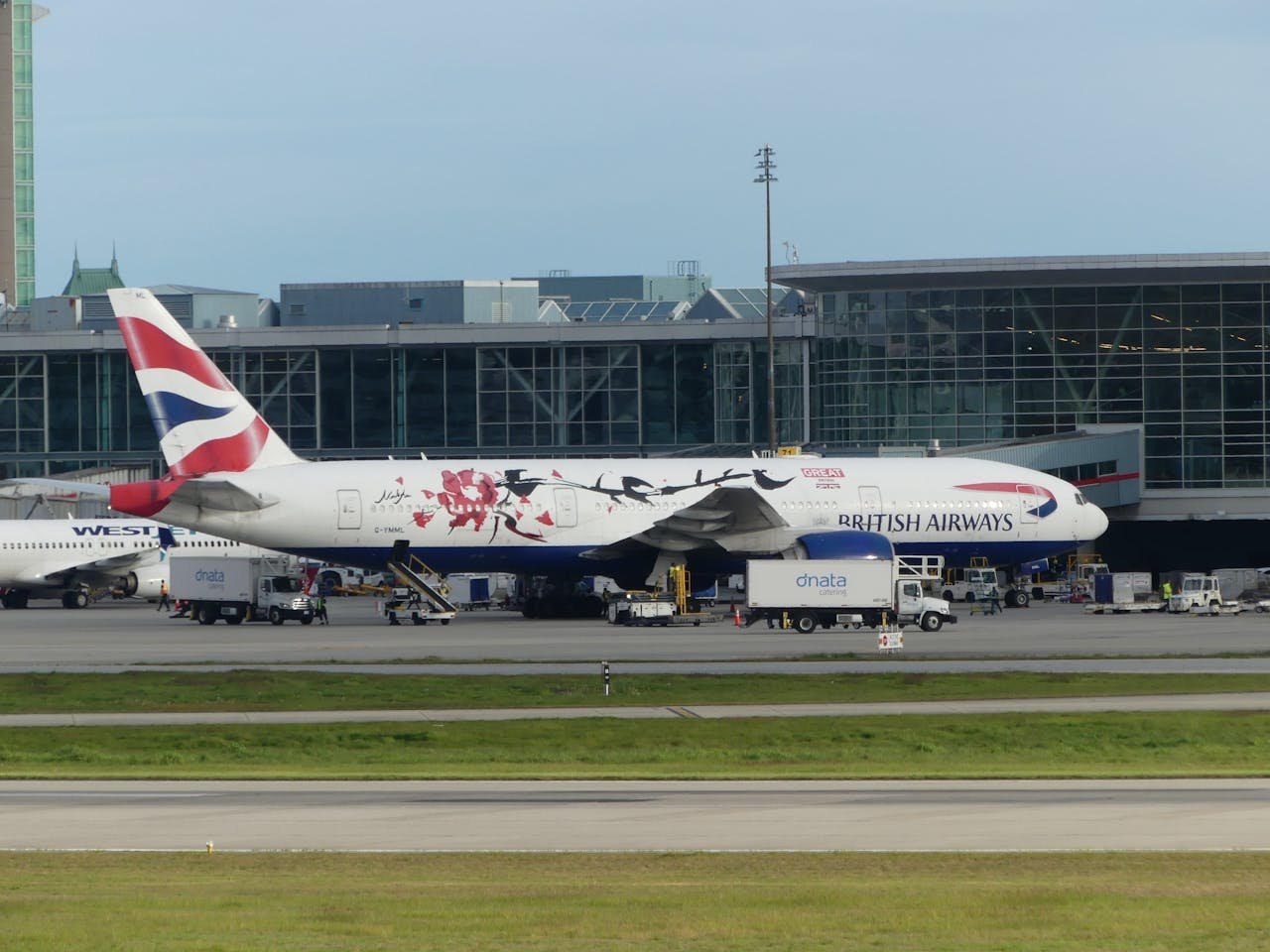 team-03 British Airways airplane on a runway at an international airport terminal ready for boarding.