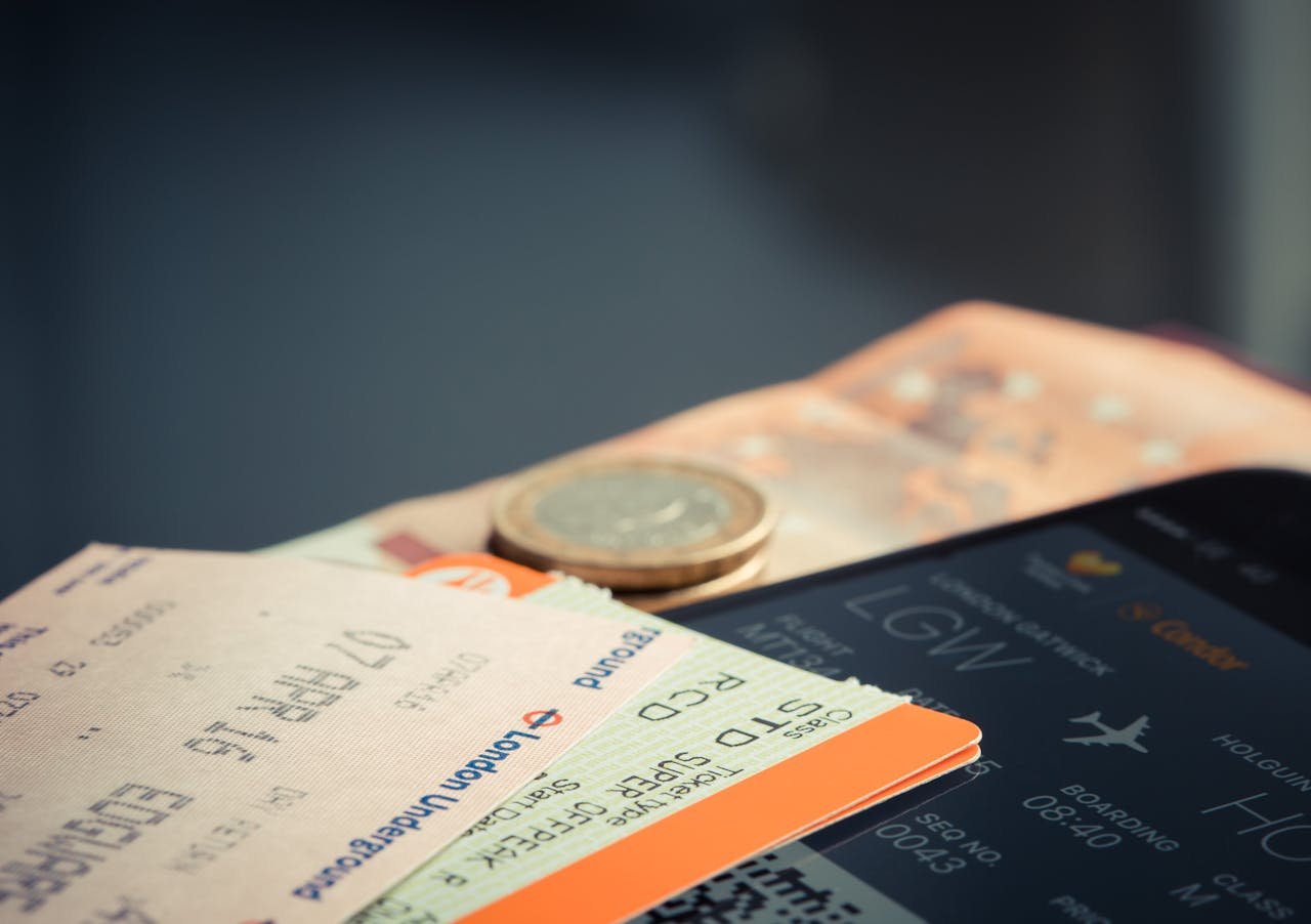 journey Airline ticket with euro coins and smartphone displaying flight details.