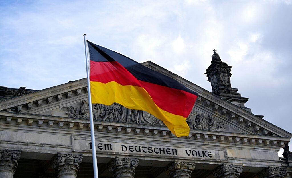 pexels photo 109629 109629 German national flag waving in front of the Reichstag building in Berlin, a symbol of democracy.
